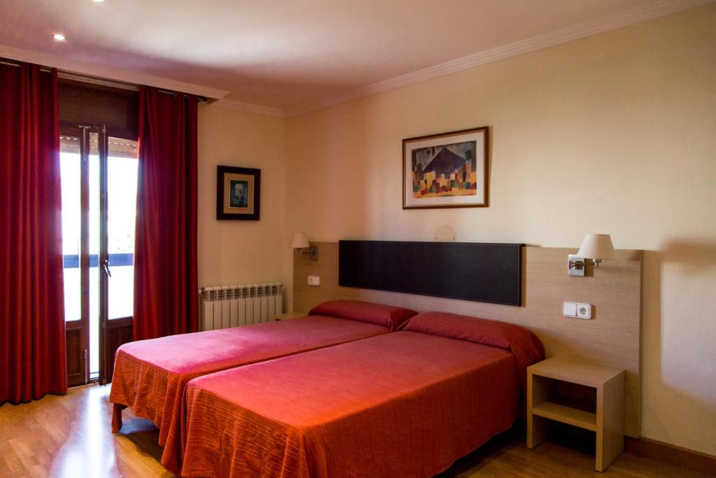 拉塞尼亚Hostal Casa Manolo的一间卧室配有红色的床和红色毯子