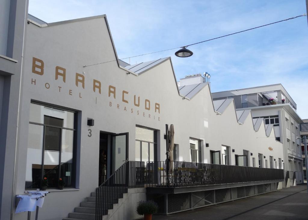 伦茨堡拜拉库达酒店的白色的建筑,上面标有读取Barragori酒店顾问的标志