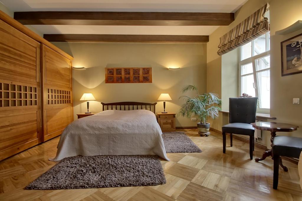 维尔纽斯皮里艾斯公寓的一间卧室配有一张床、一张桌子和两块地毯。