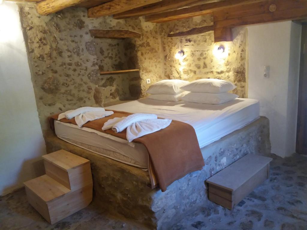 SpílionHeracles Traditional Cretan Houses的卧室配有一张石墙床