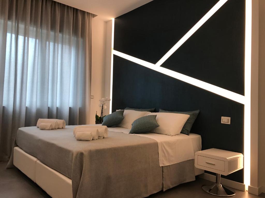 维博瓦伦蒂亚CALAMO -HOTEL -RESIDENCE- B&B的一间卧室设有一张大床和黑色墙壁