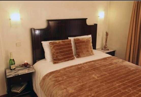 波尔图帕兰卡酒店的一间卧室配有一张大床和两个枕头