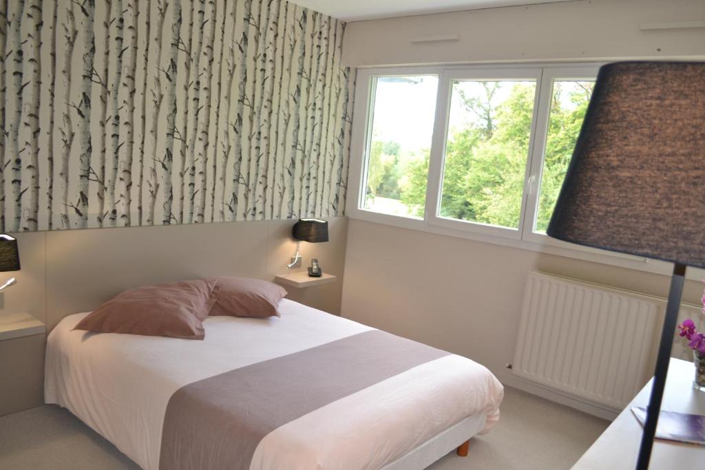 塔朗斯Hôtel de Guyenne的卧室配有白色的床和窗户。