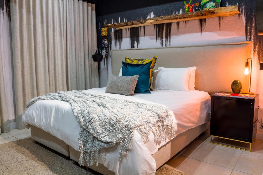 比勒陀利亚Bly B&B的卧室配有带枕头的大型白色床