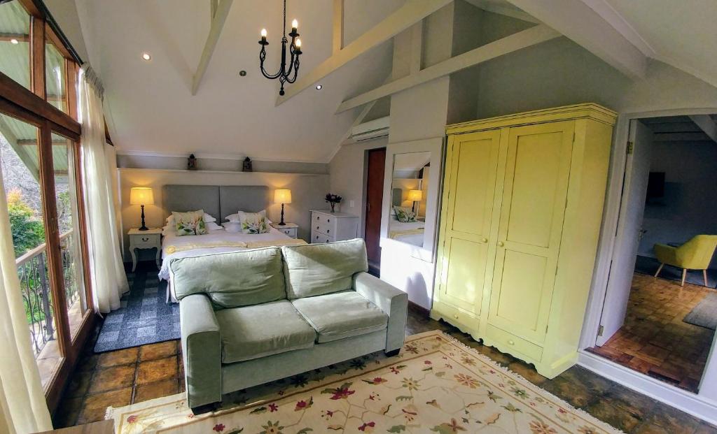 斯泰伦博斯Aan De Vliet Guest House的一间卧室配有一张床、一张沙发和一把椅子