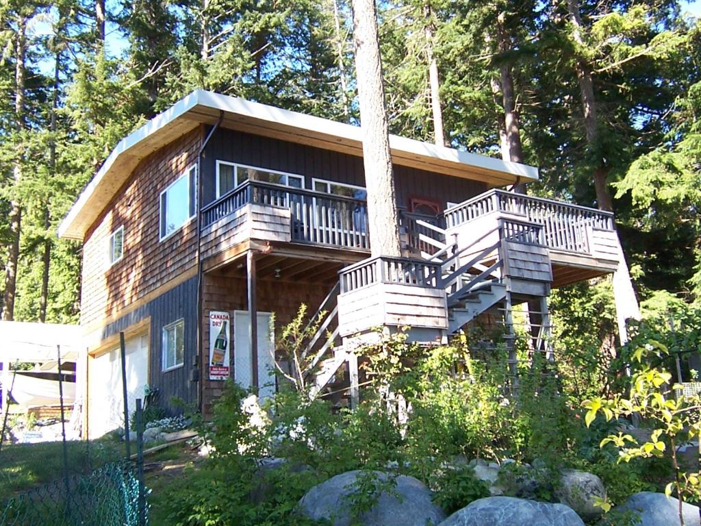 鲍威尔里弗Malaspina Strait Cottage的带阳台和楼梯的大型木屋