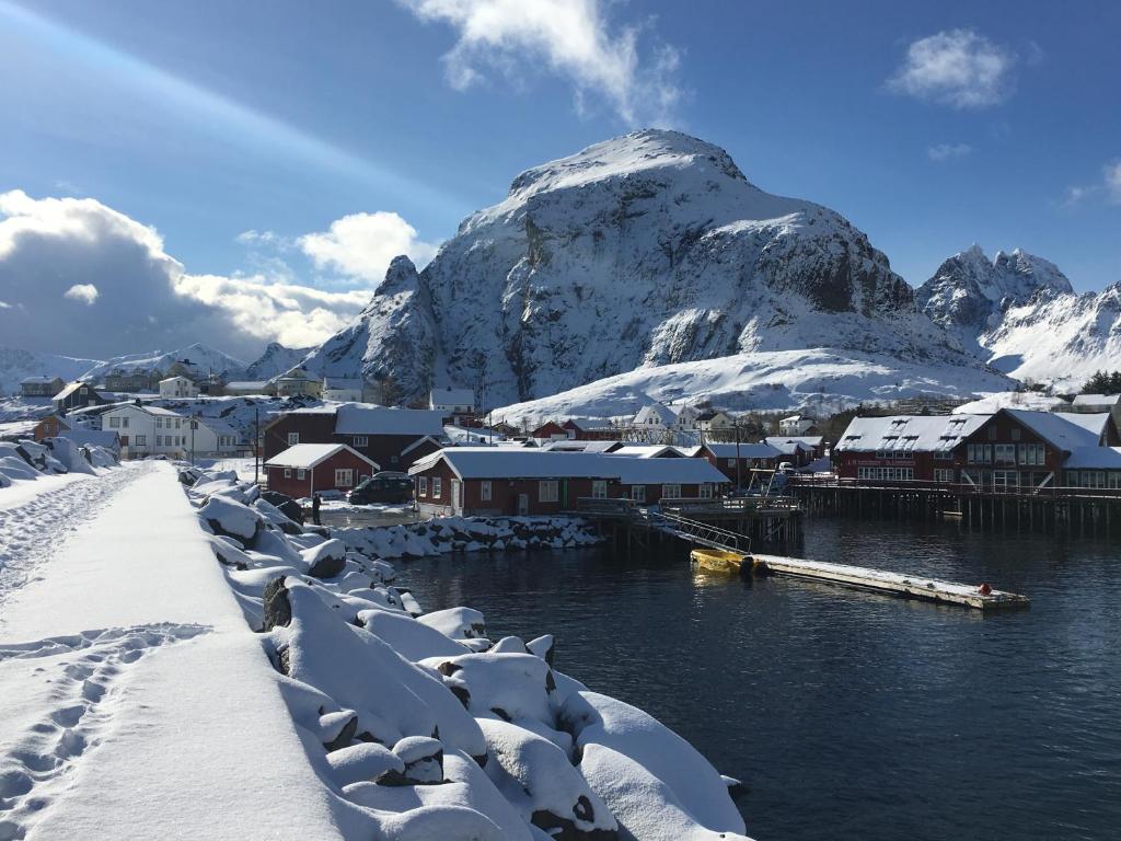 奥镇Lofoten Fishing的一座有雪盖建筑和山的城镇