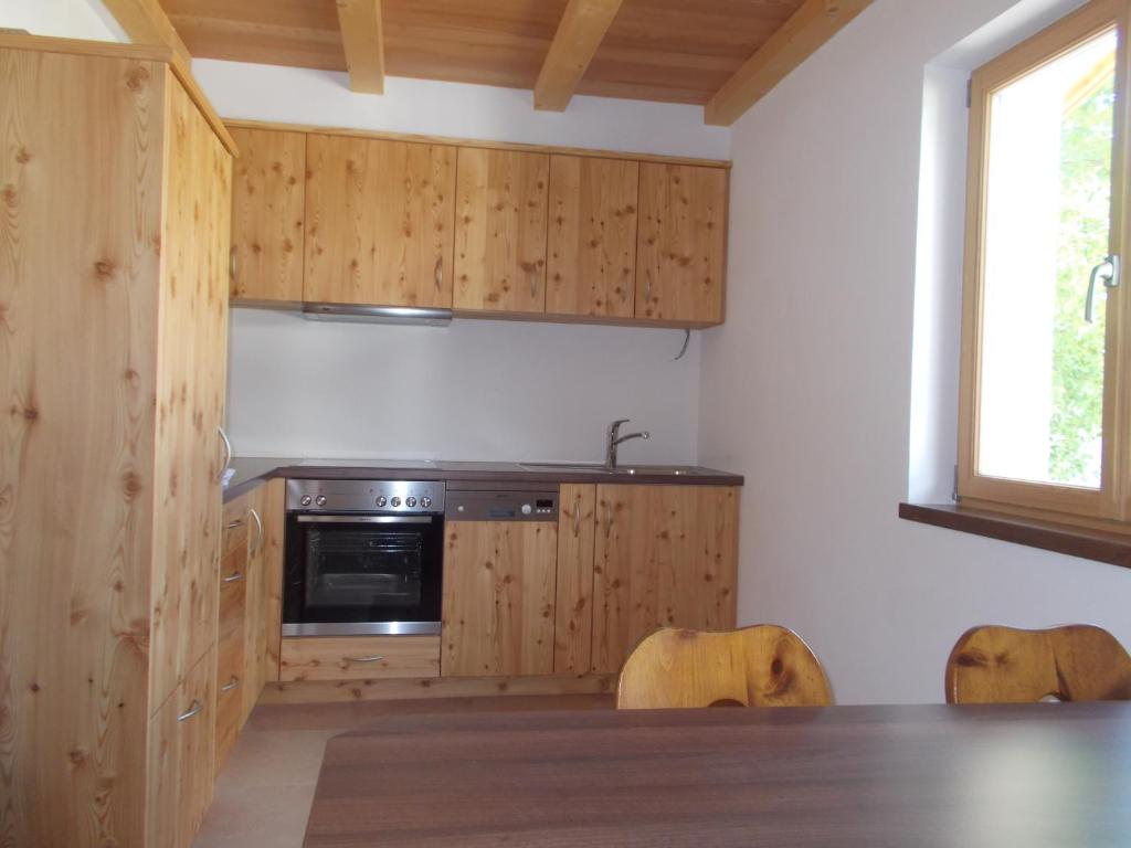 布列瑟农Pichlerhof的厨房配有木制橱柜和桌椅