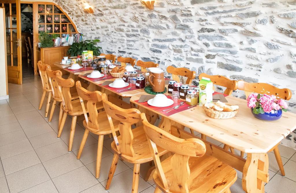 欧苏瓦拉罗什杜克劳住宿加早餐旅馆的一张长木桌子,上面摆放着椅子和食物