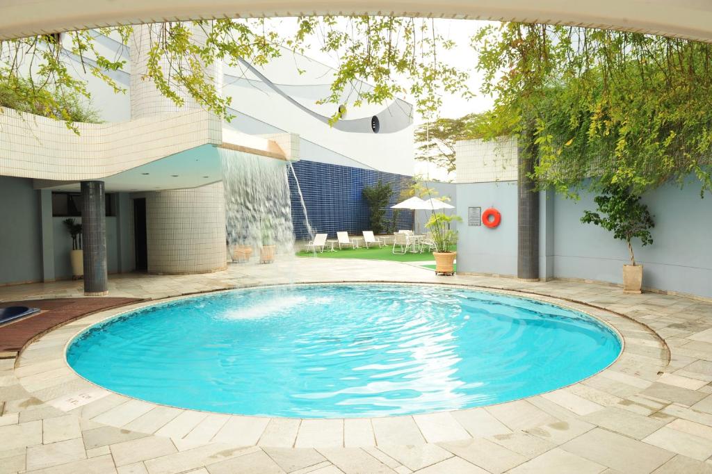普雷图河畔圣若泽圣保罗里约普雷图品质酒店的一座带房子的庭院内的游泳池