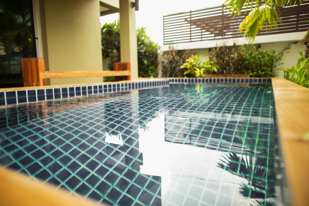 Bang Kew Yai素万那普公寓式酒店的房屋中间的游泳池