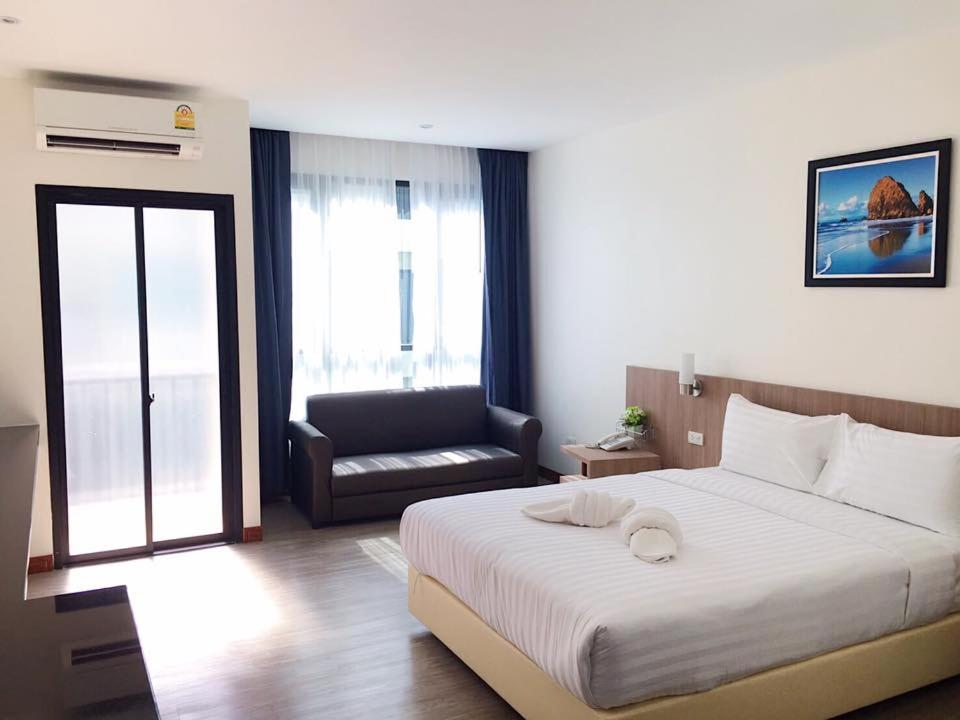 素叻兰花江景酒店的卧室配有一张白色大床和一把椅子