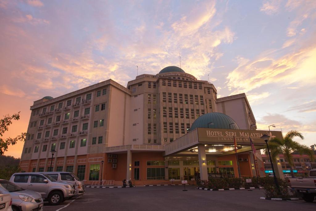 拉瓦斯马来西亚老越塞里酒店的一座大型建筑,前面设有停车场