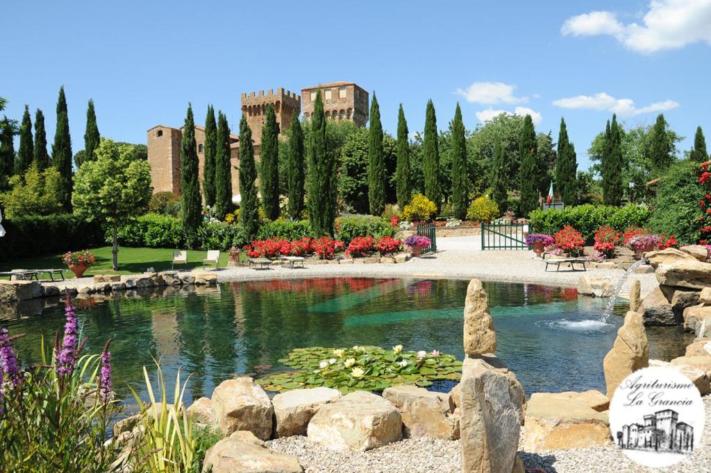 皮恩扎拉格兰西亚迪斯本达勒特农庄堡酒店的一座花园,花园内设有一个花池和一个建筑