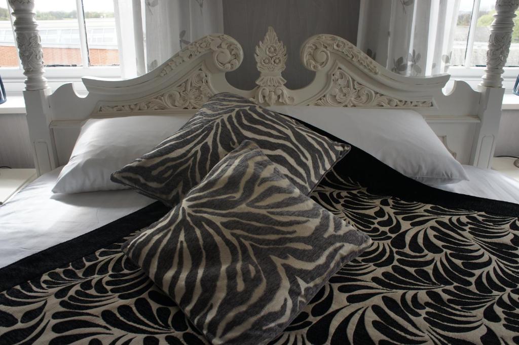 韦克菲尔德约克别墅酒店的白色的床、黑白色的棉被和枕头