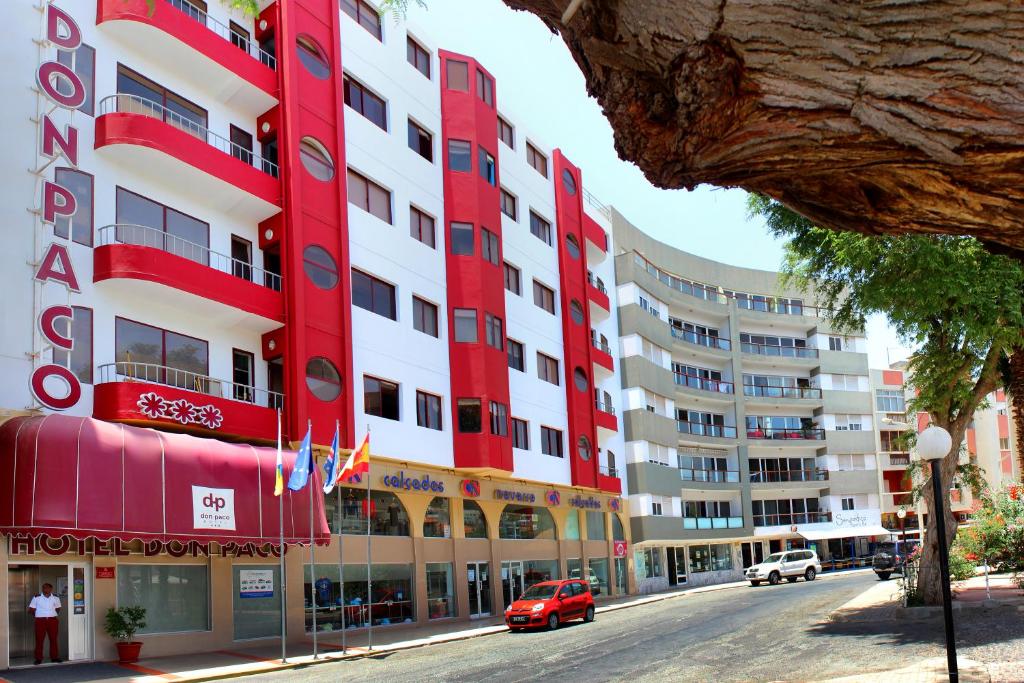 明德卢Hotel LIVVO Don Paco的城市街道上的一座红白色建筑