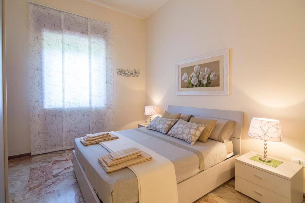 马利耶Villa Lazzari B&B Tra i due Mari的一间卧室设有一张大床和一个窗户。