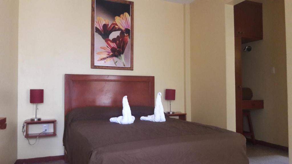 瓦哈卡市佛罗里达瓦哈卡酒店的一间卧室配有一张带白色毛巾的床