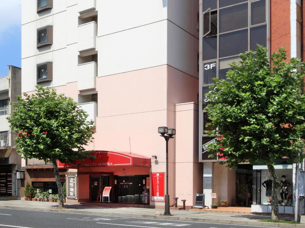 盛冈盛冈珍珠城市饭店的前方树木林立的街道上的建筑
