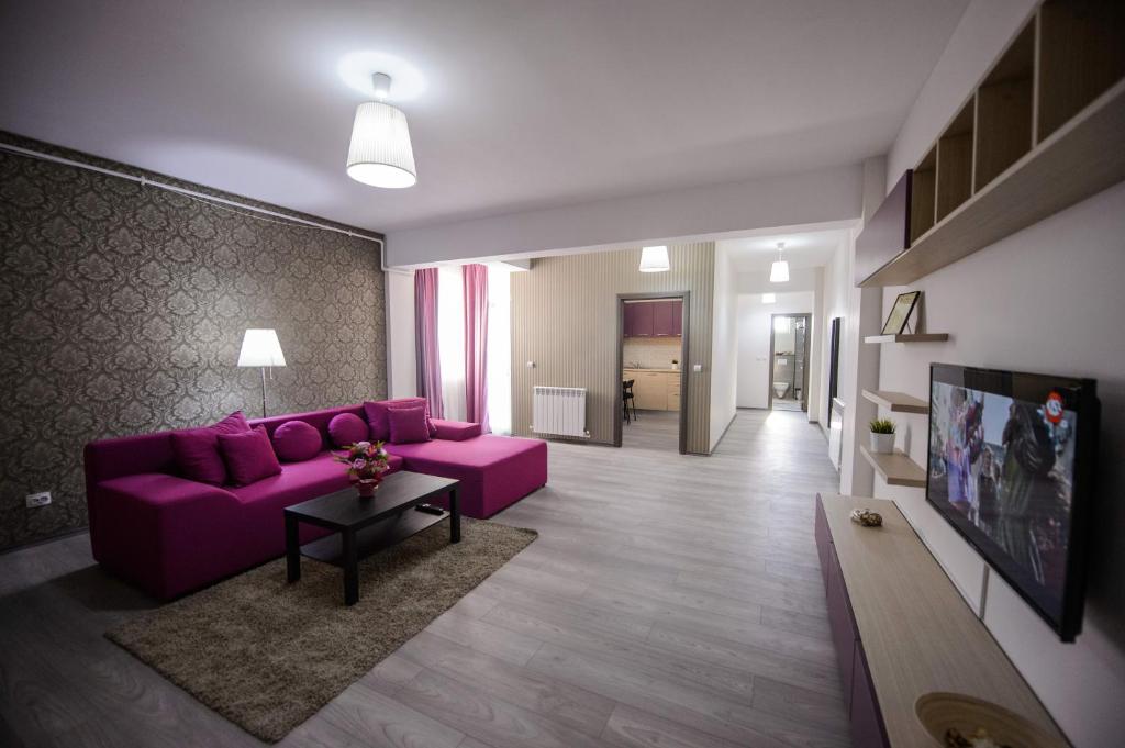 北马马亚-讷沃达里Magnum Residence的客厅配有紫色沙发和桌子
