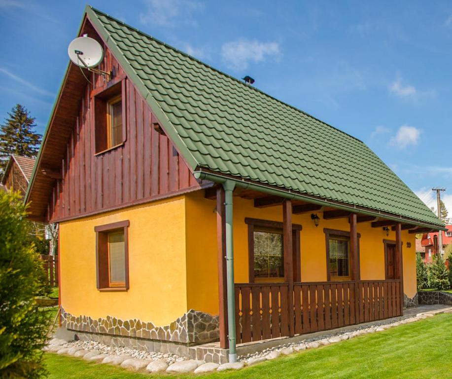 里托斯基挪威克Chata Beňušovce的黄色和橙色的绿色屋顶房屋
