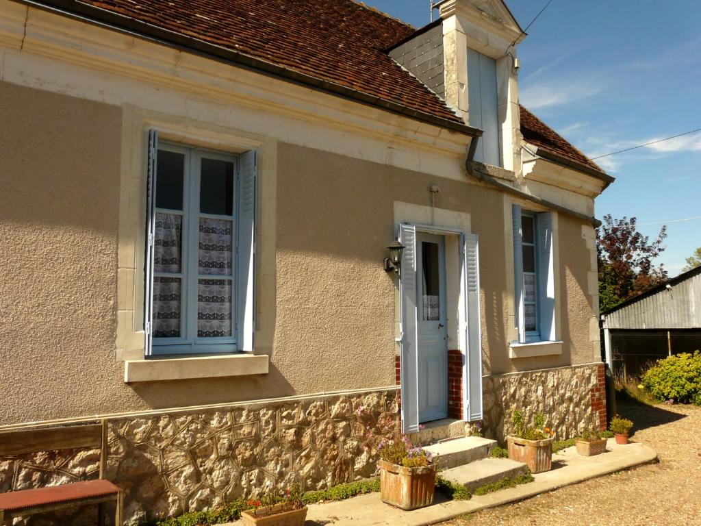 Mareuil-sur-CherGîte La P'tite Fugue的一座带蓝色门和一些植物的房子