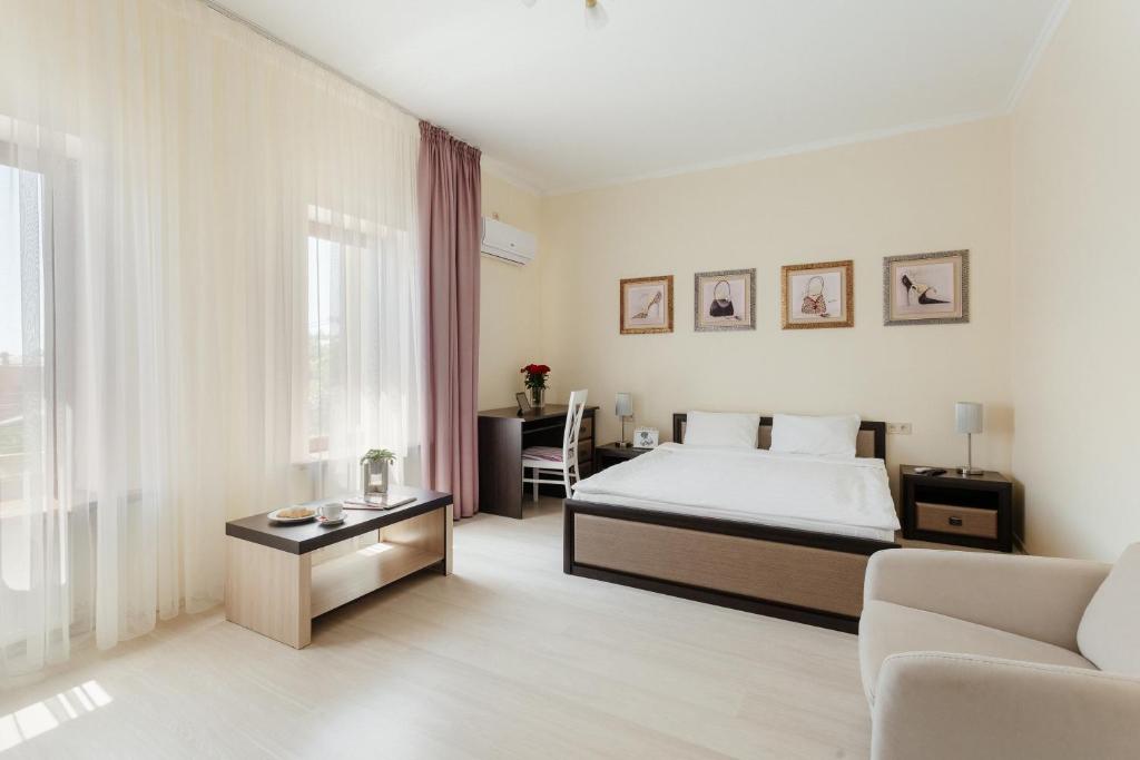敖德萨阿西叶宾馆的一间卧室配有一张床、一张沙发和一张桌子
