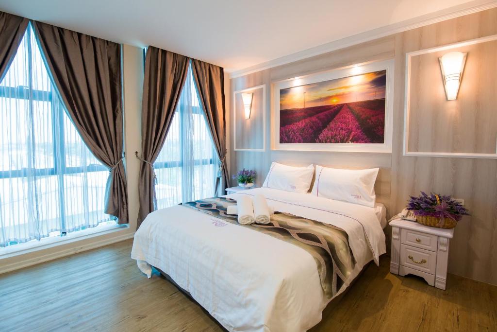 梳邦再也USJ拉文德酒店的卧室设有一张带窗户的白色大床