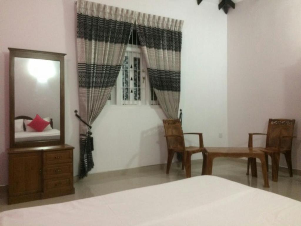 尼甘布Ahasna Family Villa的卧室配有床、镜子和椅子