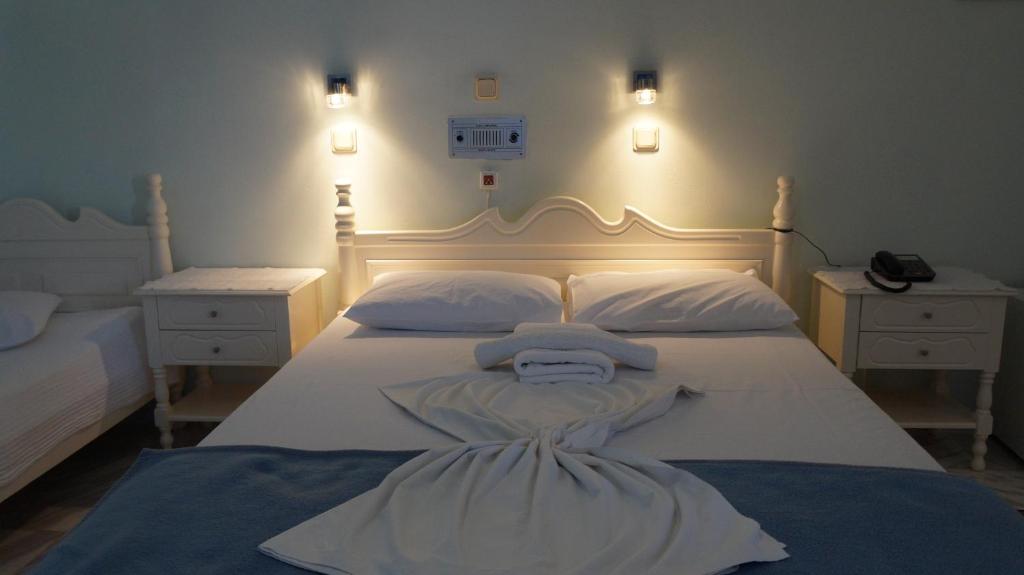 卡罗维西阿曼达酒店的一间卧室配有白色床和2个床头柜