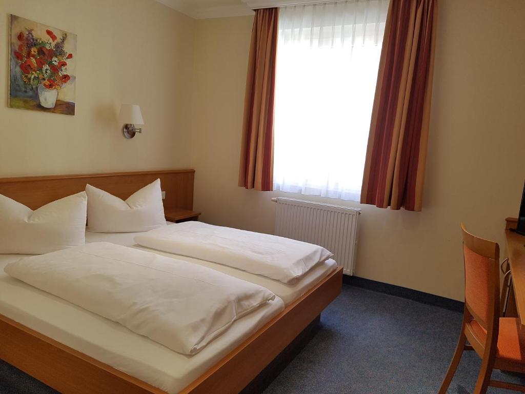 纽伦堡加尔尼凯穆尔酒店的一间卧室配有一张带白色床单的床和一扇窗户。