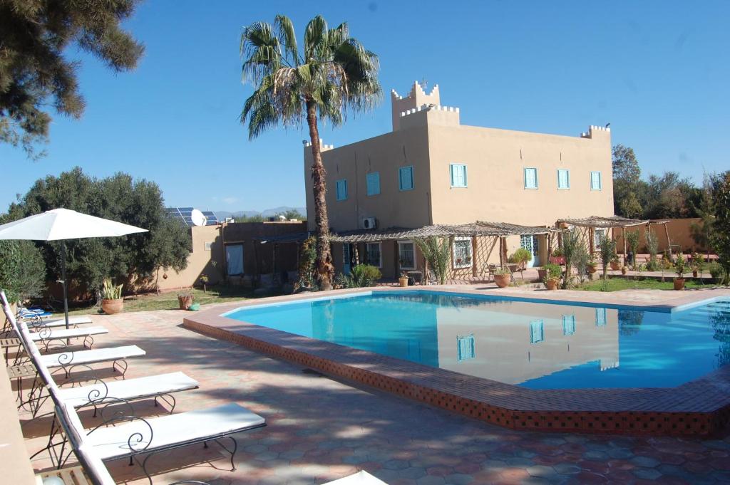 Oulad TeïmaGite Souss的一个带椅子的游泳池和一个背景建筑