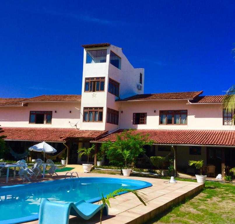 萨尔瓦多Pousada da Mércia - Itapuã (BA)的一座带游泳池和大楼的度假村