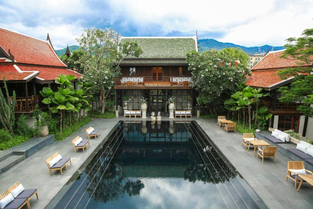 清迈Villa Mahabhirom - SHA Plus的一座带房子的建筑前的游泳池