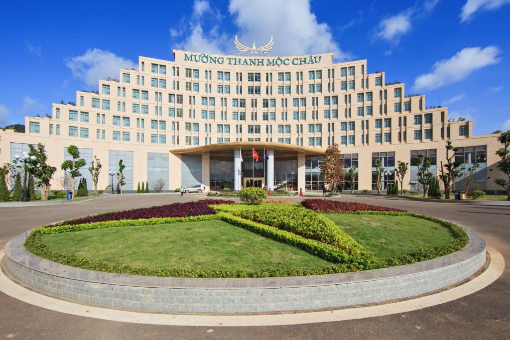 木州县蒙坦假日莫绍酒店的一座白色的大建筑,前面有一个圆圈
