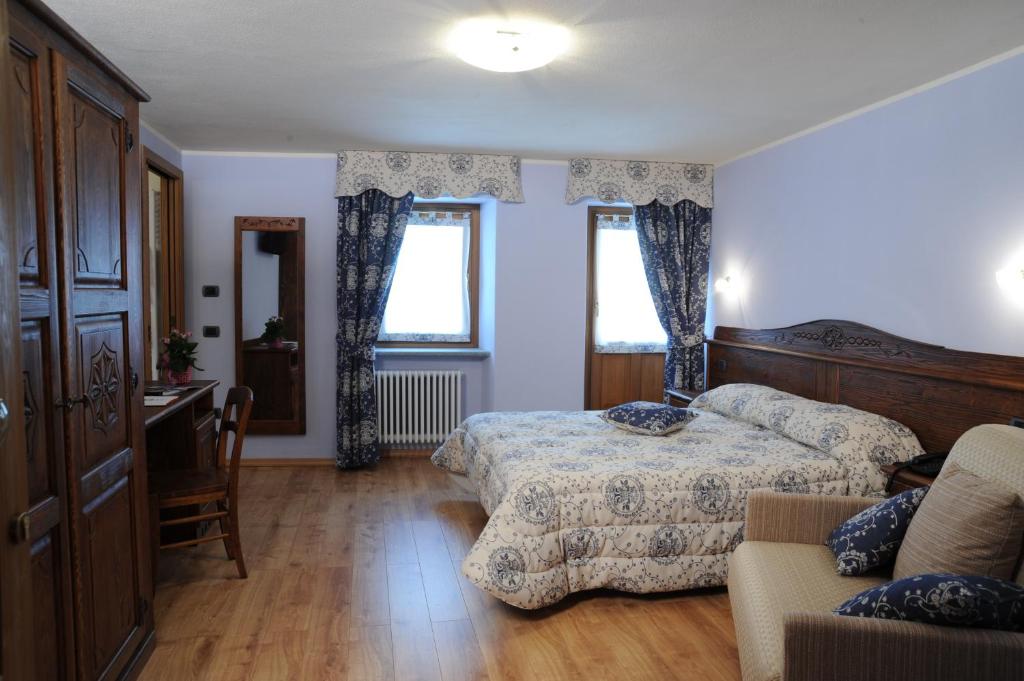 瓦尔佩利内弗兰蔻乡村民宿的一间卧室配有一张床、一张书桌和两个窗户。