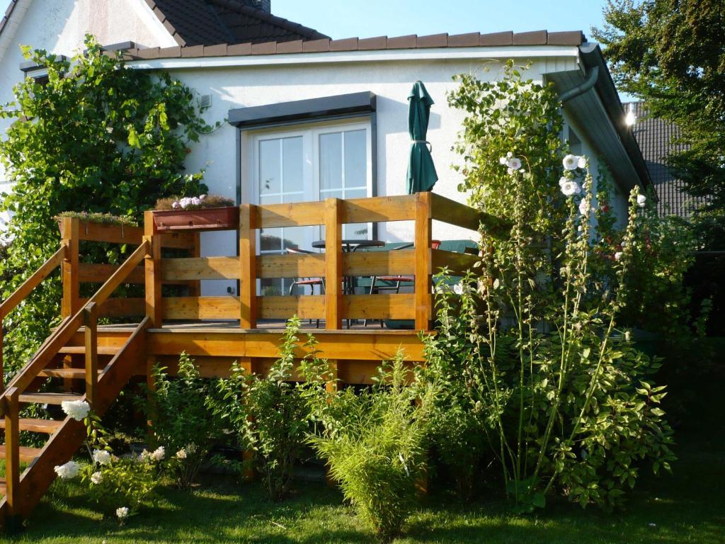 萨加尔德Fewo in sonniger Lage in Sagard的庭院中带木甲板的房子