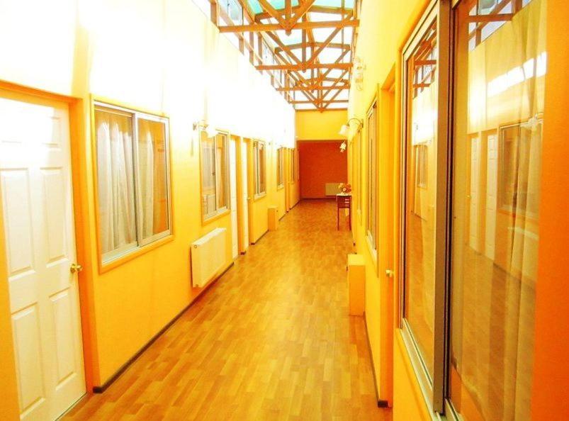 特木科安达鲁特姆科酒店的一条空的走廊,有黄色的墙壁和木地板