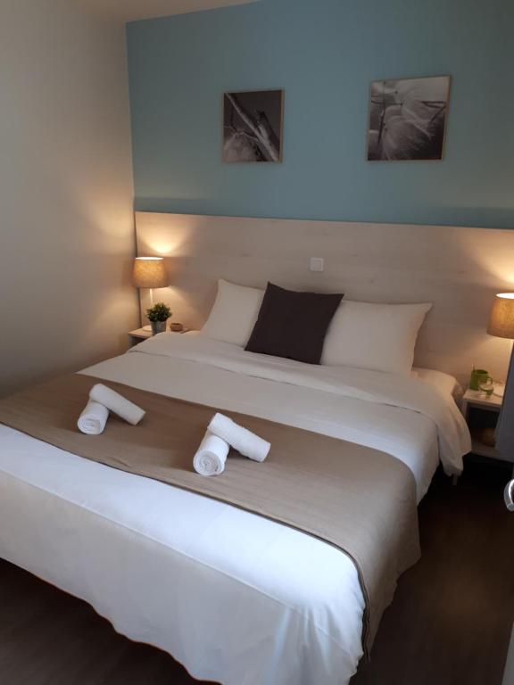 弗尔黎祖VVF Normandie Forges-les-Eaux的一间卧室配有一张大床和两条毛巾