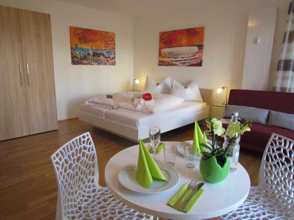 慕尼黑市容园林公寓 的客厅配有桌子和床。