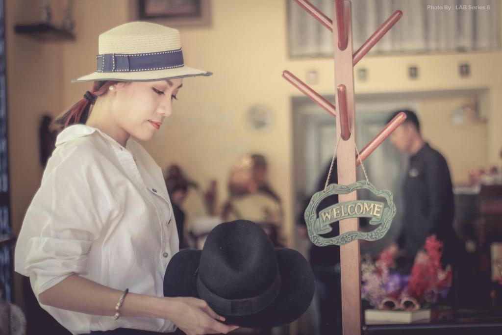 曼谷常忆住宿加早餐旅馆 的女人在展览上戴帽子