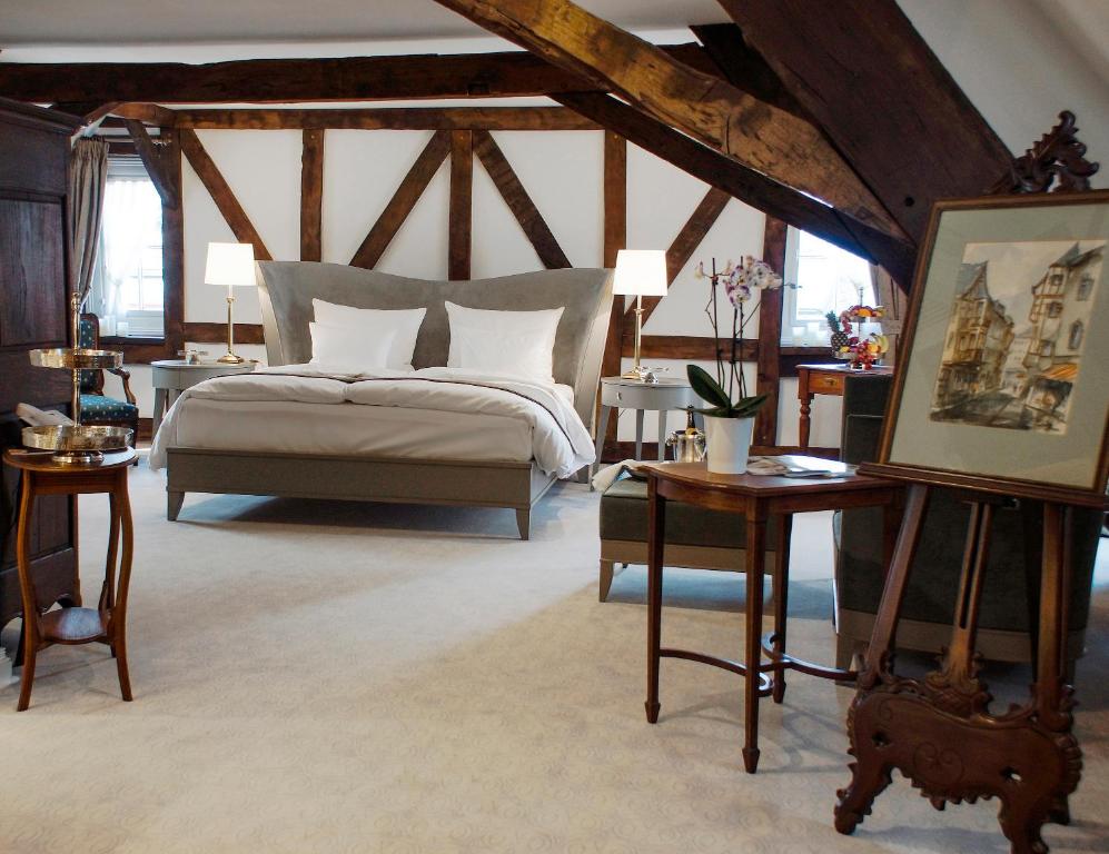 特里尔钟声浪漫酒店的卧室配有一张床铺,位于带横梁的房间内