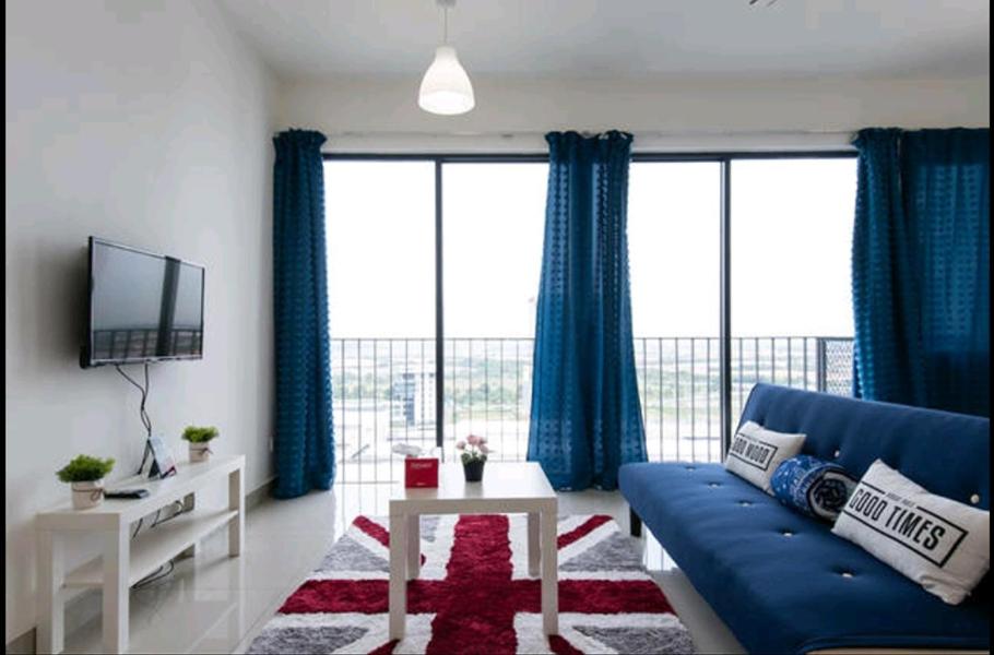 实达阿南特瑞福赛特爱姆米卡公寓的客厅配有蓝色的沙发和蓝色的窗帘