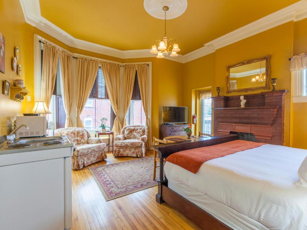 圣约翰奇普曼山套房酒店 - 悉尼街 的一间卧室设有黄色的墙壁、一张床和一个水槽