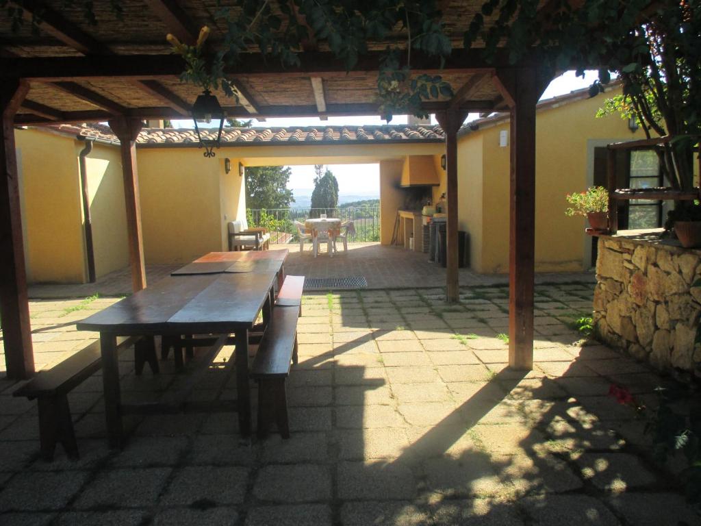 萨尔泰阿诺Agriturismo Stigliano的天井设有木桌和凉亭。