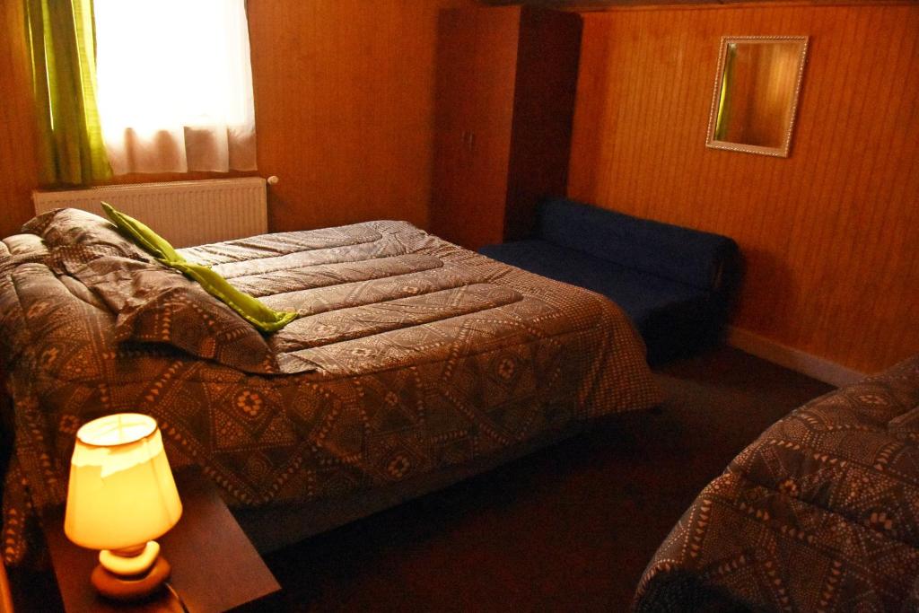 纳塔列斯港卡瓦尼亚斯巴塔哥尼亚英斯图公寓的一间卧室配有一张床和一张带台灯的桌子