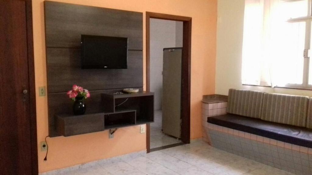 皮乌马Apartamento em Piúma-ES的一间带电视和沙发的客厅