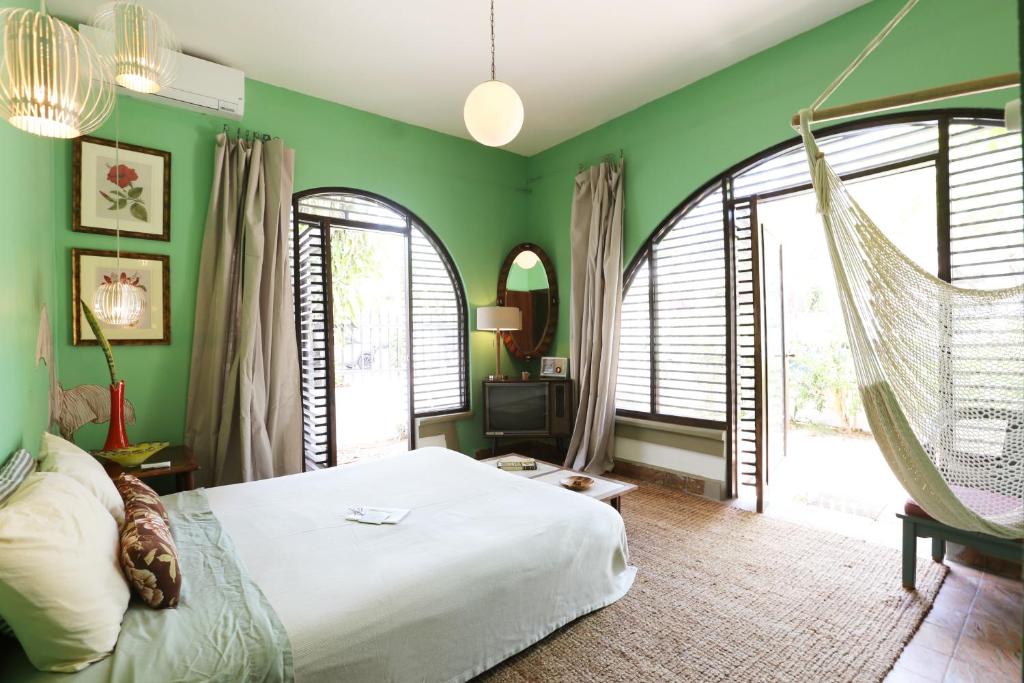 圣胡安DREAMCATCHER by DW的一间卧室设有绿色的墙壁和一张秋千床。