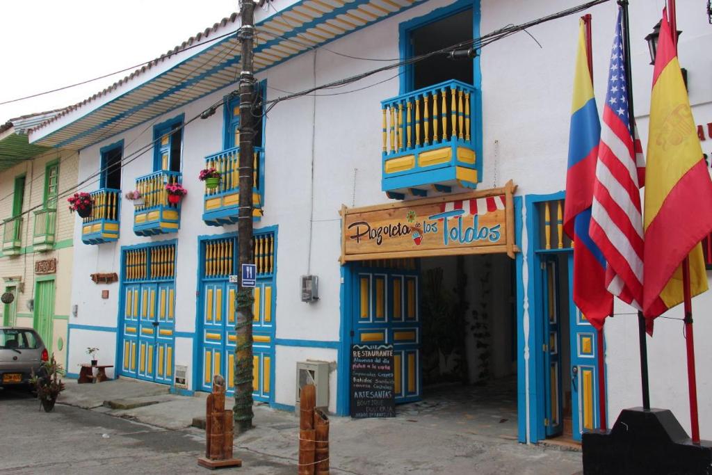 菲兰迪亚Apartahotel Calle del tiempo detenido的一座拥有蓝色和白色墙壁和旗帜的建筑