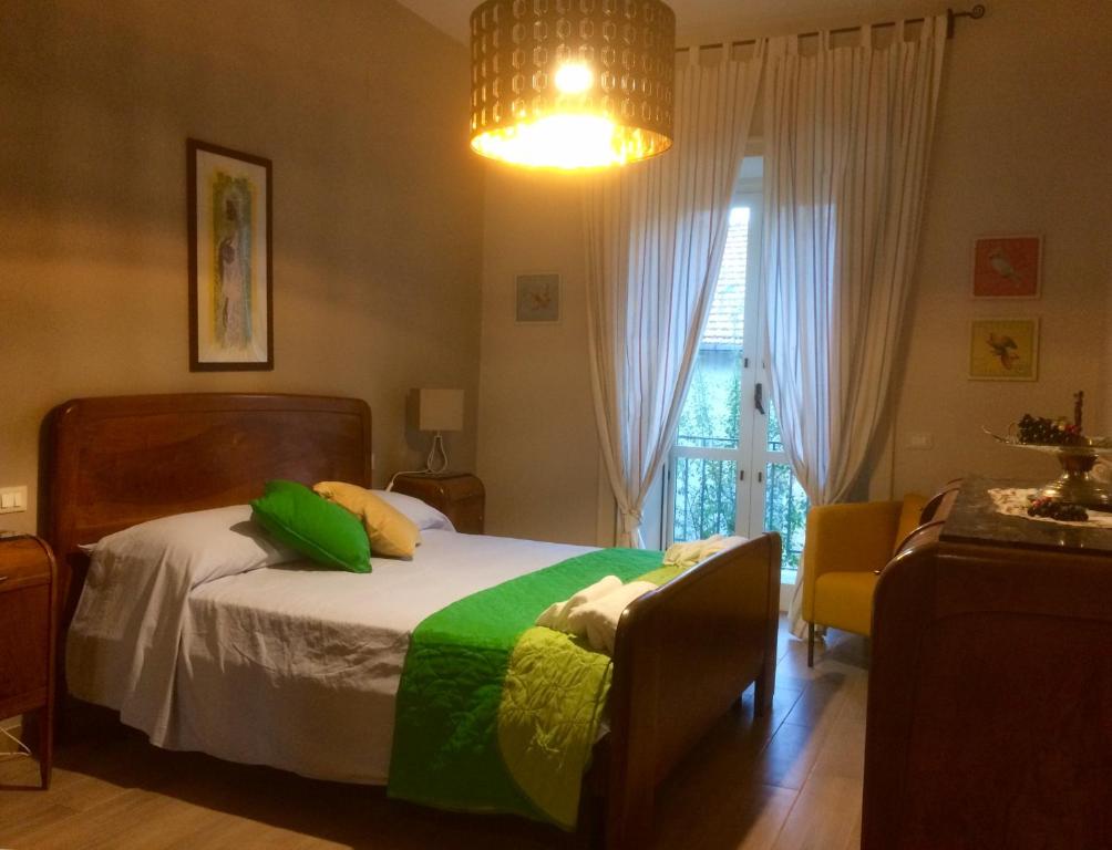 阿杰罗拉Gli dei e le Rose的一间卧室配有一张带绿色和黄色枕头的床
